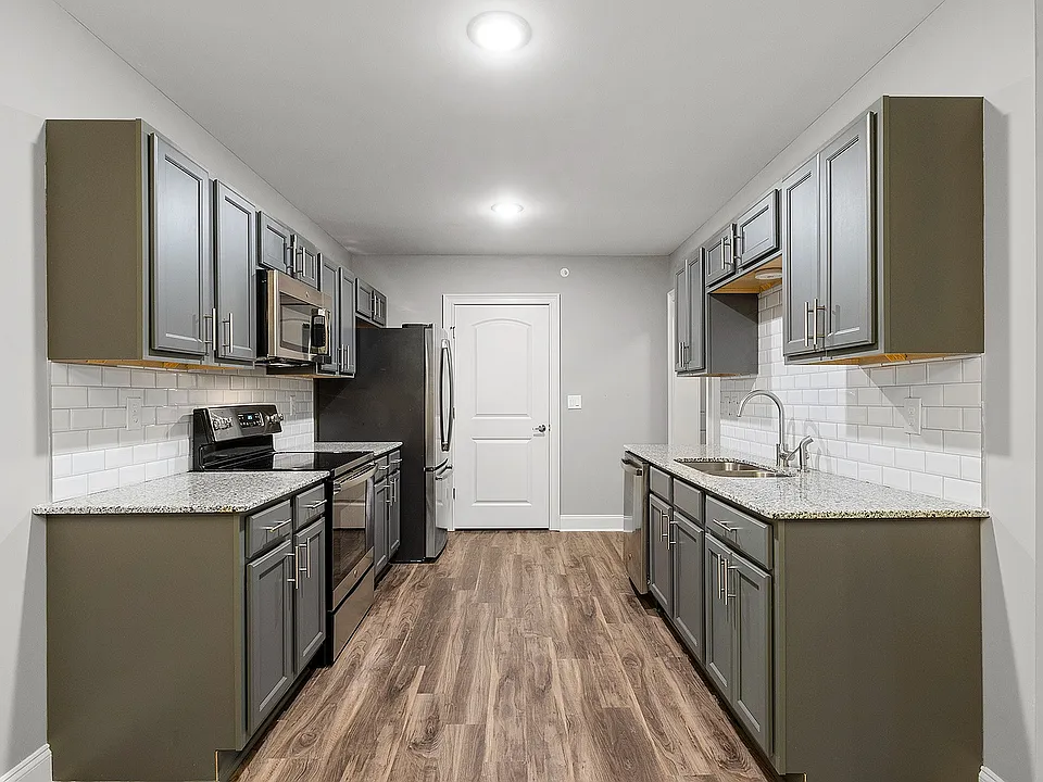 Sleek modern kitchen featuring elegant grey cabinetry, stainless steel appliances, and stylish wood flooring.
