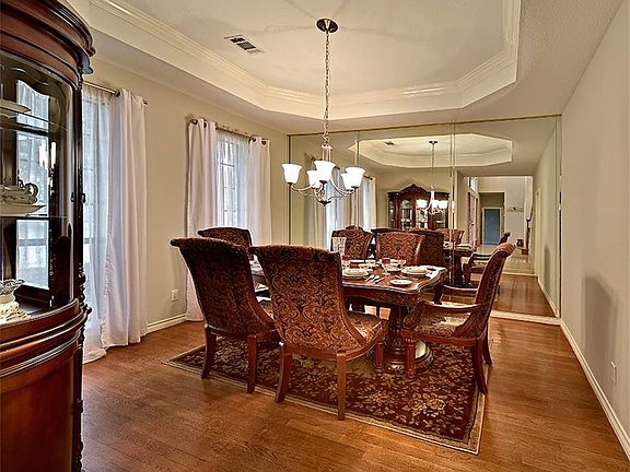Formal dining room with hardwood flooring.
