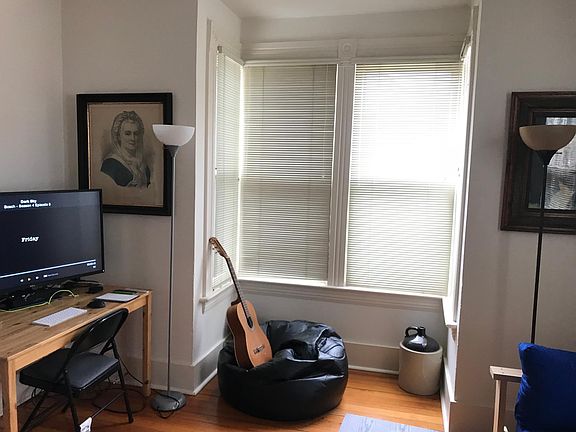 View of living room and large bay window from front door