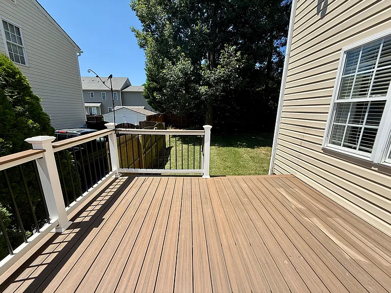 Deck leads down to a fully fenced in side yard.
