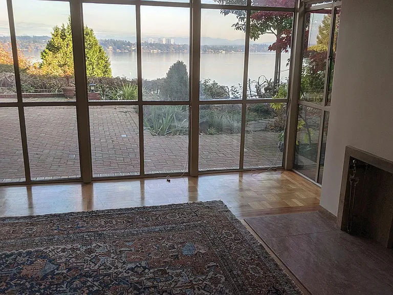 Living room has wall of windows with Roman shades. Marble fireplace. Hardwood parquet floors. Rug has been removed (please see next photo)