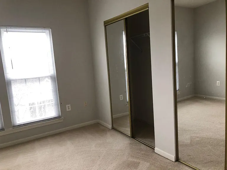 Second bedroom with large mirrors and closet