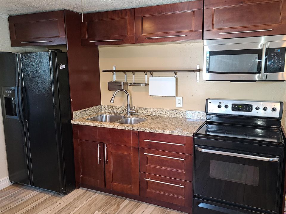 custom kitchen with granite countertops, full size range, side by side refrigerator with water and Ice, Microwave.