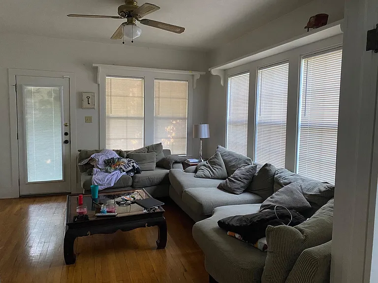 Living Room - (facing front door) original hardwood floors, 9 ft. ceiling, 5 large windows with blinds, shleving above windows, ceiling fan, opens onto Dining Room through French doors.