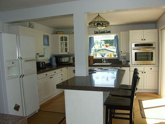 gourmet kitchen w/ granite counters, bamboo flooring under counter lighting