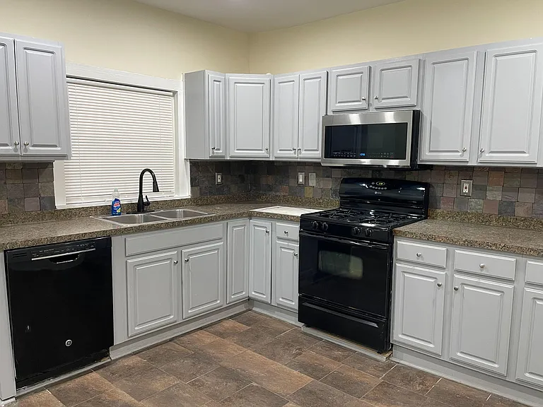 U-shaped kitchen offers ample cabinet storage, generous counter space, and a full appliance suite for easy meal prep.