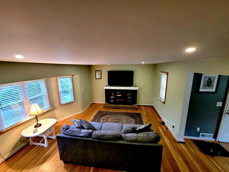 Living room with 65" Smart TV and electric fireplace.