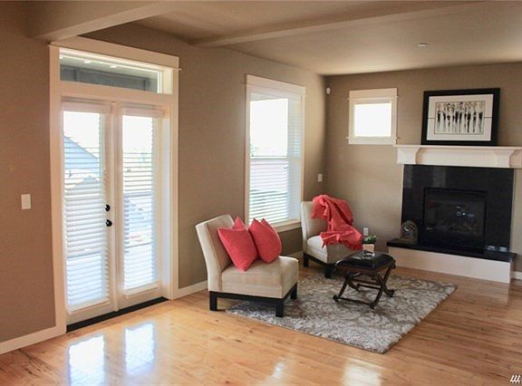 Front living room adjoins the entry and features the same wood floors, gas log fireplace and French doors that open to balcony with commanding views of the development and Blacks Hills.