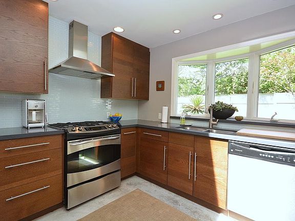 Fabulous Gourmet Kitchen with stained concrete flooring, bay window overlooking backyard, skylight &