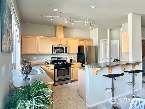Granite eating bar, ceramic tile flooring, stainless steel appliances, gas cooktop.  Top Floor Eastern Corner Unit with lots of windows and light!>