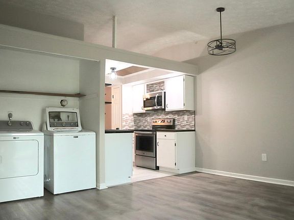Backroom that flows into kitchen with laundry area.