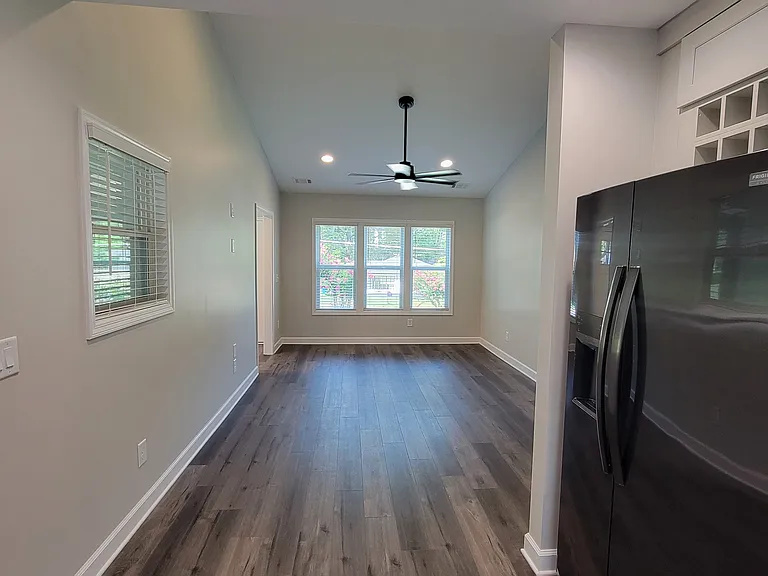 Vaulted ceiling and ceiling fan in living room.