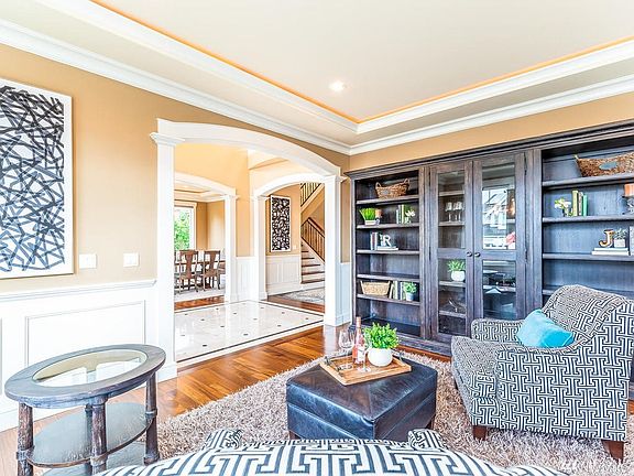 Formal living room features backlit tray ceiling, extensive woodwork, Brazilian Cherry hardwood floors