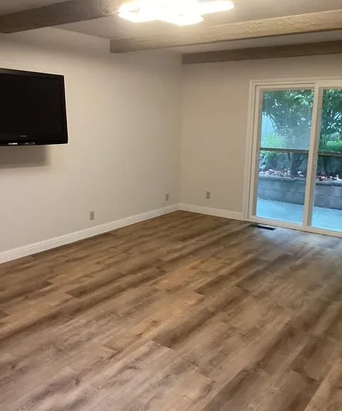 TV room. Slider to side yard and garage access (separate door not pictured).