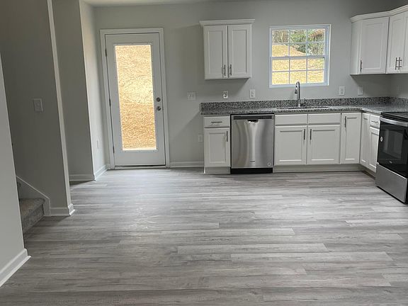 another angle of the kitchen viewing the back door and entrance to the laundry room and the upstairs