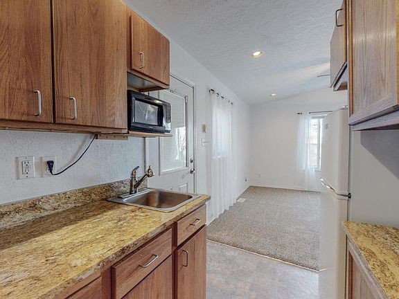 Kitchen with fridge, microwave and stove top