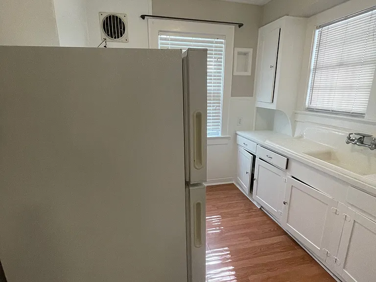 Kitchen with double porcelain sink original cabinets refrigerator stove and other 1950s era art deco details