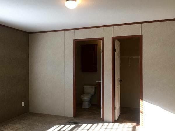 Master bedroom with attached master bathroom and walk-in clo