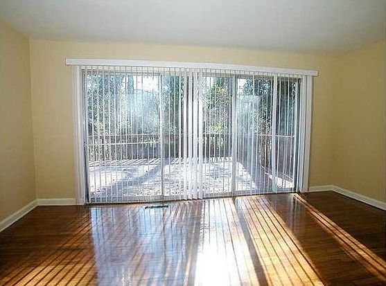 Sunlit dining or living room looks out to back deck.