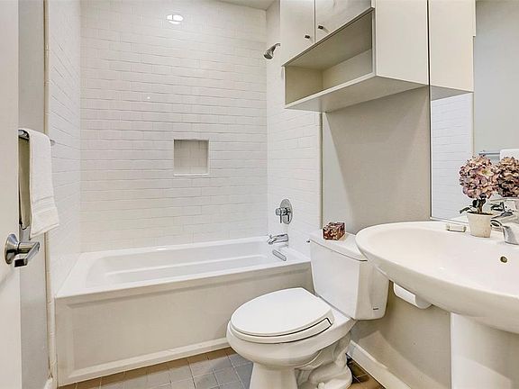 The second-floor ensuite bath features a stylish pedestal sink and classic subway tile. A brand-new toilet has been installed for your convenience