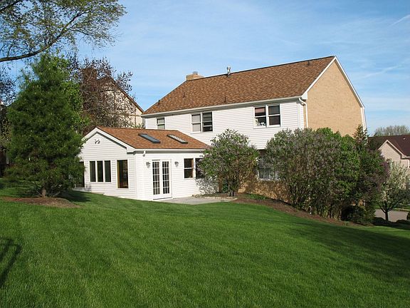 Rear of house shows 380 sq. ft. sun room, large backyard, landscaping