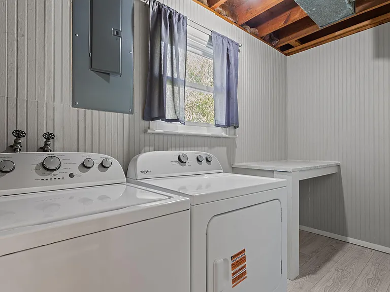 Laundry room with new full-size washer and dryer for residents use, folding counter, and a window for added ventilation
