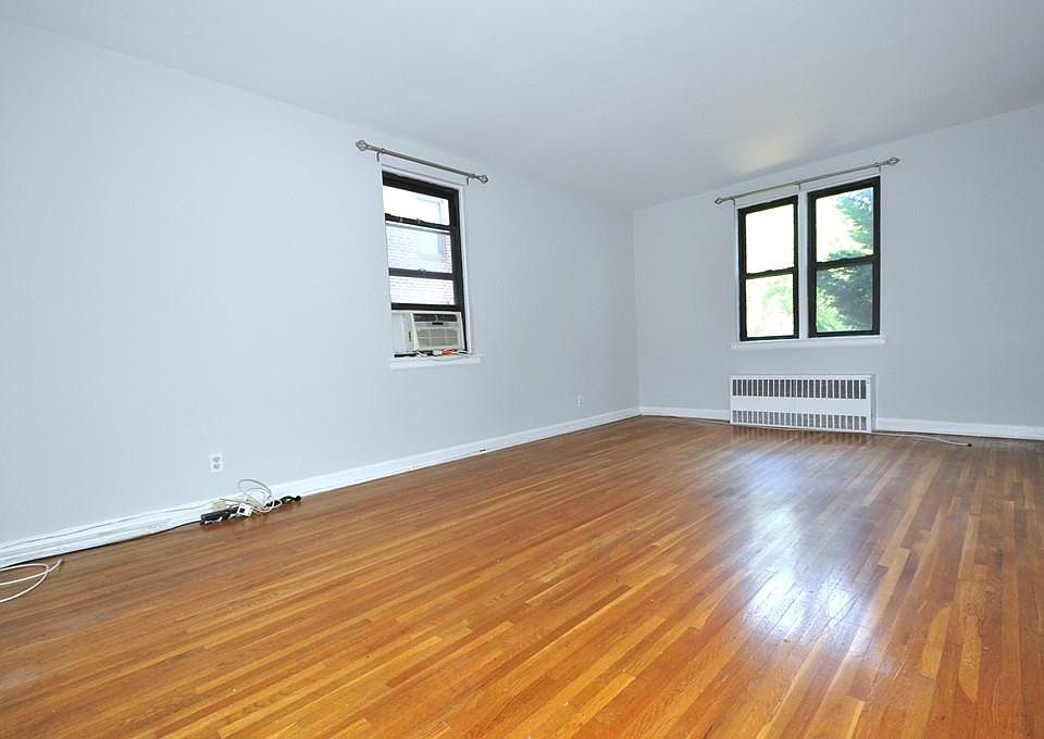 Large Corner Living Room with Hardwood floors opens to the dining foyer and overlooking Tree Lined Garth Road. The living room is 19'-10" x 12'-2".