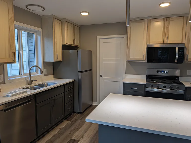 Utility room off of kitchen had an in-demand hot water heater, stackable washer and dryer, and water softener.