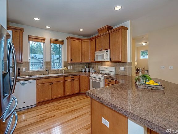 The beautiful hardwood continues into the kitchen which boasts granite counter-tops and 42" tall cabinets.