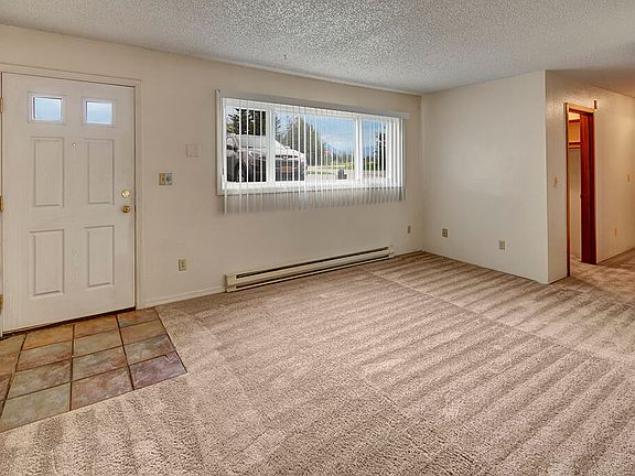 A large living room with a wide window overlooking the property