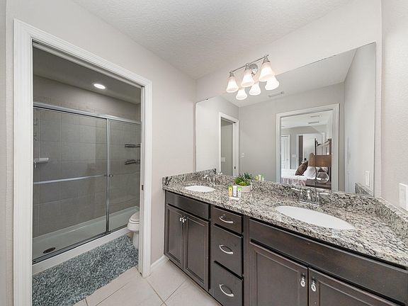 Beautifully designed bathroom with a spacious walk-in shower, granite countertops, and contemporary lighting.