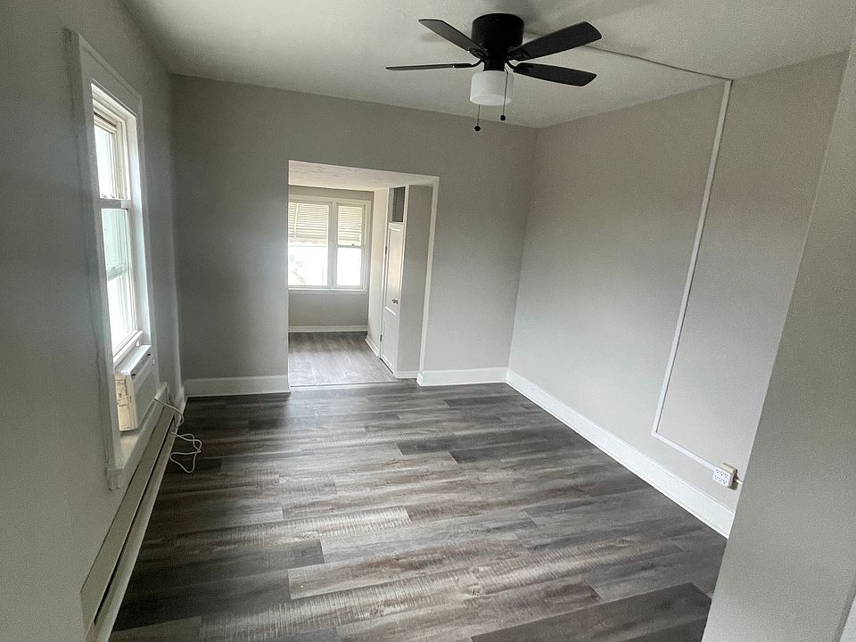 New paint, flooring and ceiling fans in the dining room. Photo taken from kitchen and living room is in background.