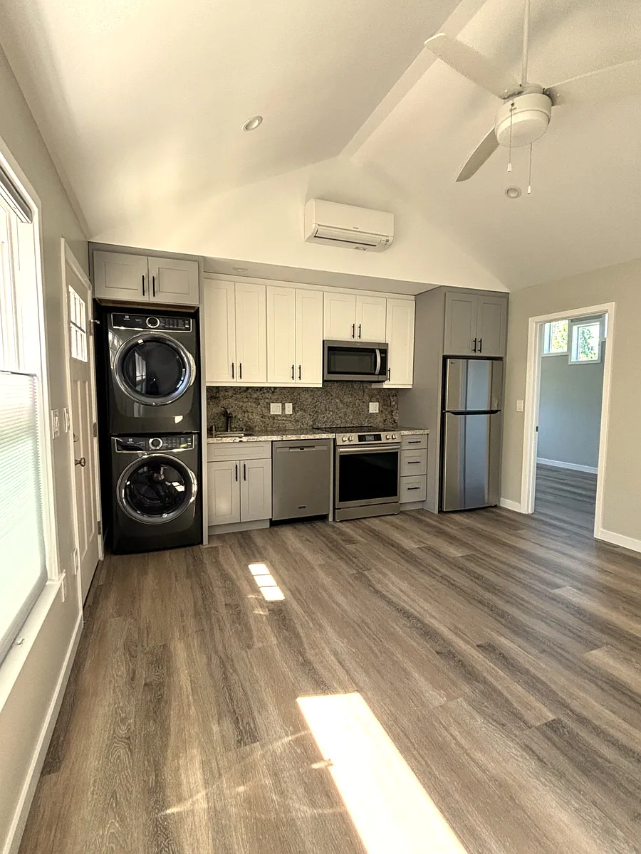 Living room and kitchen with granite counters, full size stainless steel appliances including dishwasher, range frig and washer dryer. - 3920B Wilshire Ave