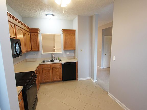 Tiled Kitchen with lots Wood Cabinets and Storage