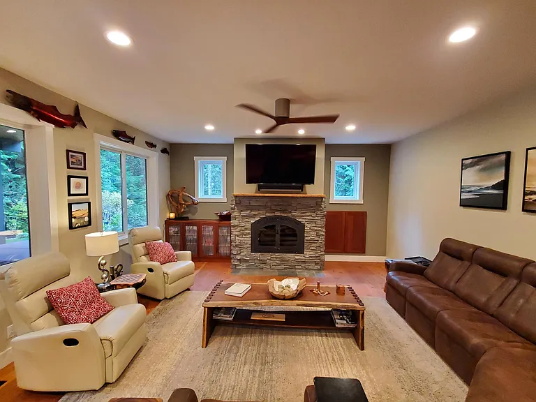 The large family room has comfortable seating and a wood burning fireplace. The cabinet doors to the right of the fireplace access the wood storage box which is loaded from the exterior. Brilliant. Minimal mess but the comfort of wood heat.