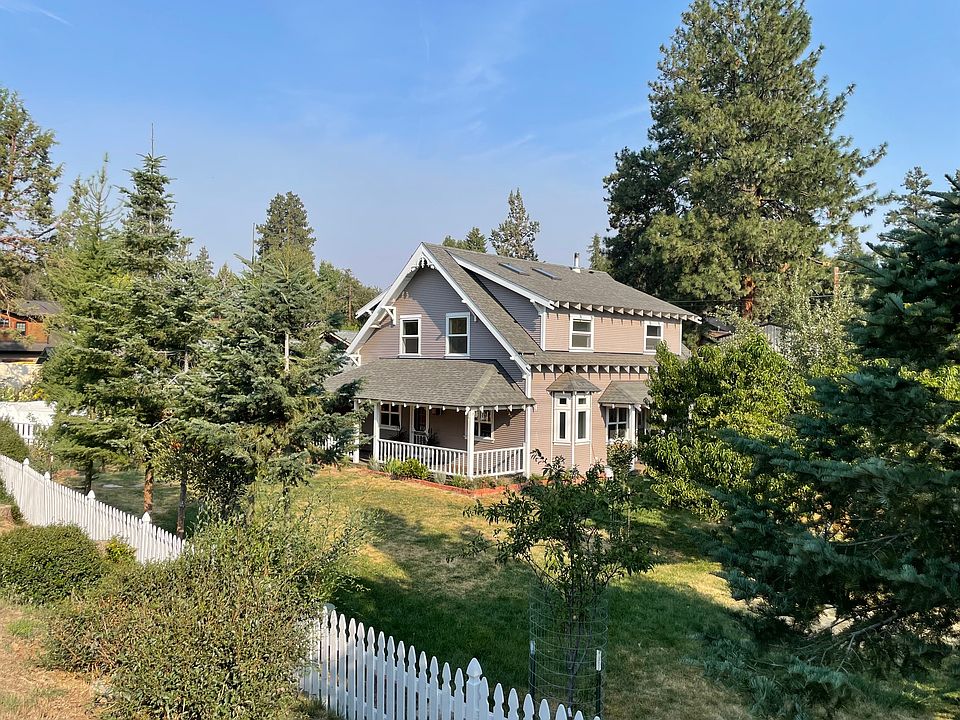 Large fenced in yard with mature fruit trees.