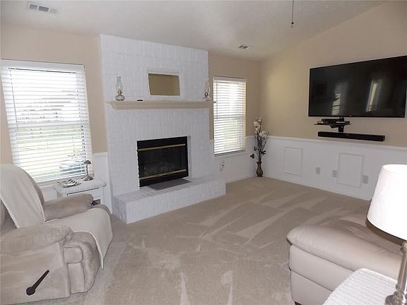 Comfortable 17 X 13 family room with vaulted ceiling, wainscoting with chair rail, and plush carpet.