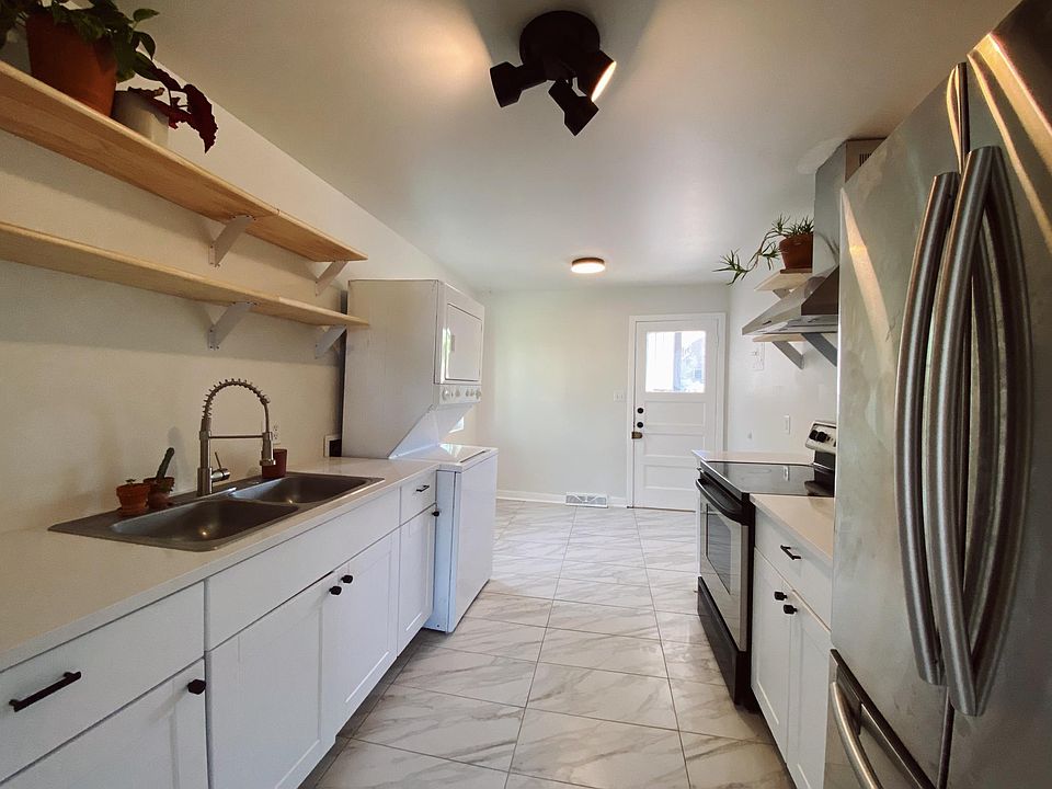 The kitchen has brand new tile, cabinets, appliances, shelving, and fixtures. Stackable washer/dryer in-unit with ample space for a seating area.