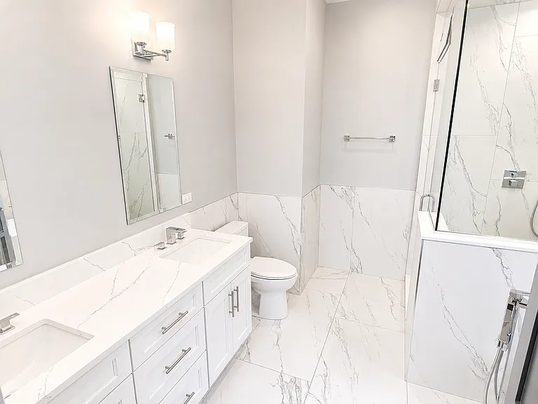 Primary Bathroom with double vanity, heated floors, custom shower and full sized soaking tub.