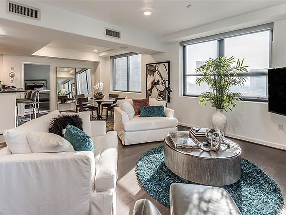 A view of the spacious open Kitchen, Dining and Living areas. This unit offers tons of windows, recently installed hardwoods and