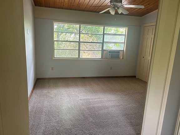 Large bedroom with ceiling fan and new carpet