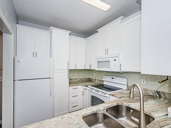 updated kitchen with newer appliances and marble countertops