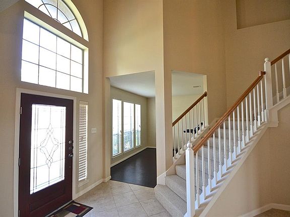 This view of the foyer shows off the beautiful leaded glass and mahogany door. The tiled foyer separates the formal rooms (Formal Living Room is ahead) and leads to the grand staircase to the second floor.