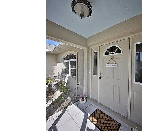 Covered entry and front door with sidelights.