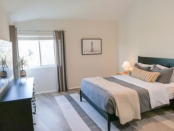 Spacious primary bedroom with vaulted ceilings and plentiful natural light!