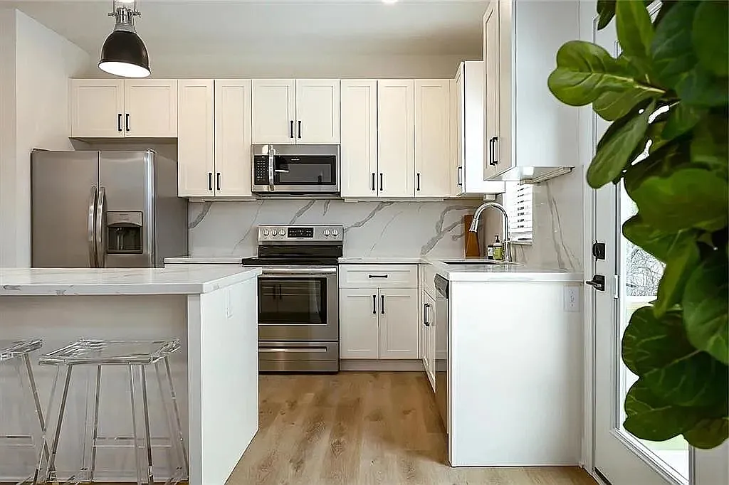 Modern kitchen featuring quartz-style countertops, stainless steel appliances, custom cabinetry, and open-concept design.

Photos are representative and finishes or layouts may vary slightly by unit. - 8206 E 65th St #8206