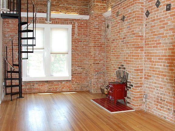 Living Room with tons of light and hardwood floors. Red fireplace.