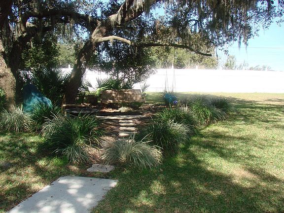 Fenced in backyard w/ tree swing