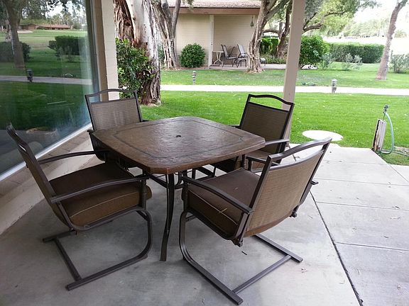 Covered patio surrounded by grass.