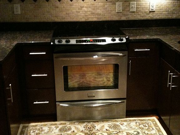 Kitchen with white stone backsplash, granite countertops
